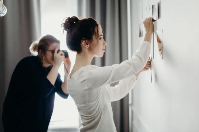 femme-qui-accroche-photos-mur